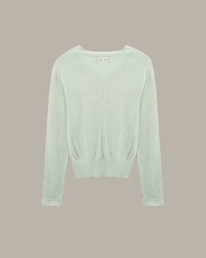 Light green sweater on a beige background