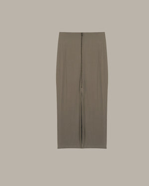 Long, dark green skirt on a beige background