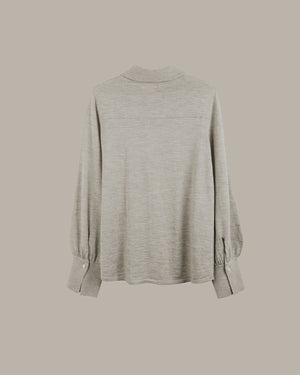 A light gray heathered long-sleeve top with a mock neck and gathered elbow cuffs, shown from the back against a solid taupe background.