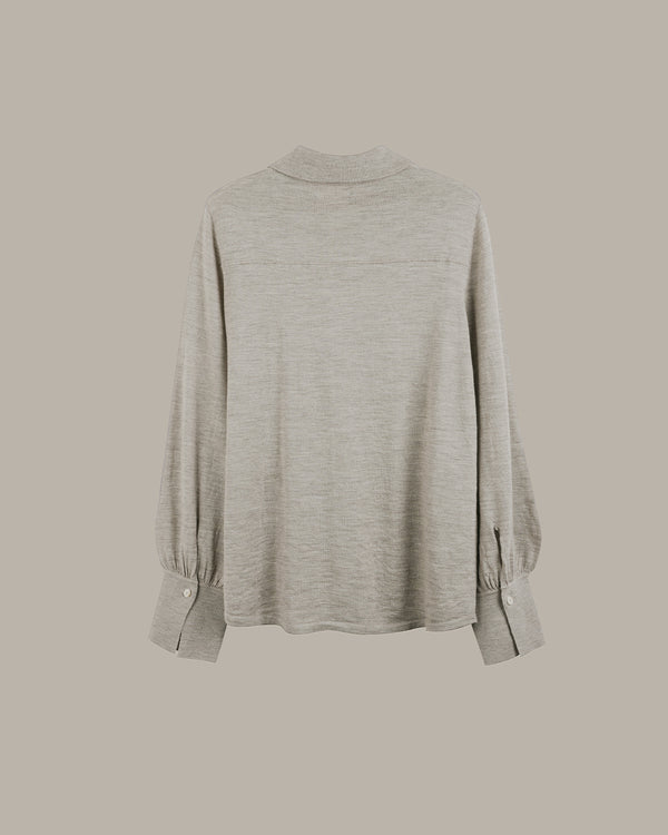 A light gray heathered long-sleeve top with a mock neck and gathered elbow cuffs, shown from the back against a solid taupe background.
