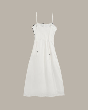 White dress with thin straps on a beige background