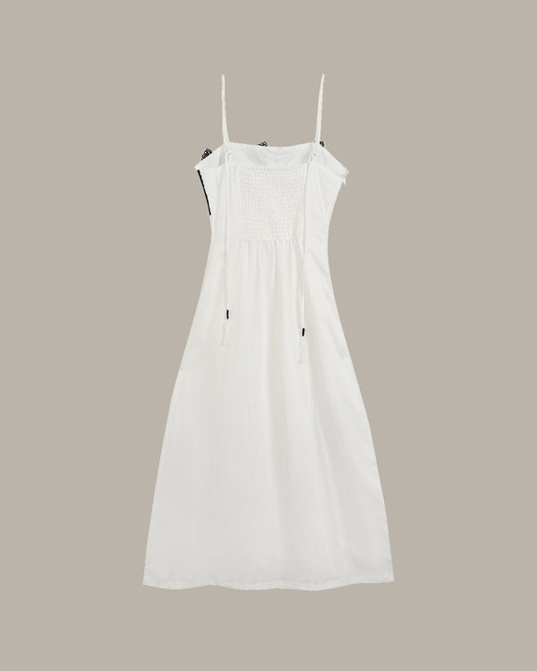 White dress with thin straps on a beige background