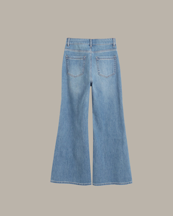 Light blue denim flare jeans shown from the back, featuring two back pockets and a wide leg silhouette, set against a solid taupe background.