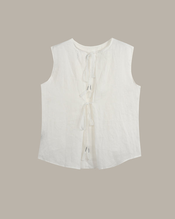 A sleeveless white top with a round neckline, front tie details, and a curved hem, shown flat against a solid taupe background.