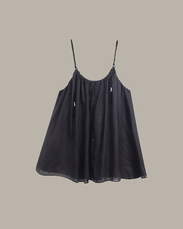 Black slip dress on a beige background
