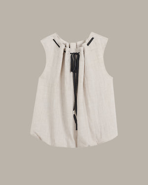 White sleeveless top with black zipper on a beige background