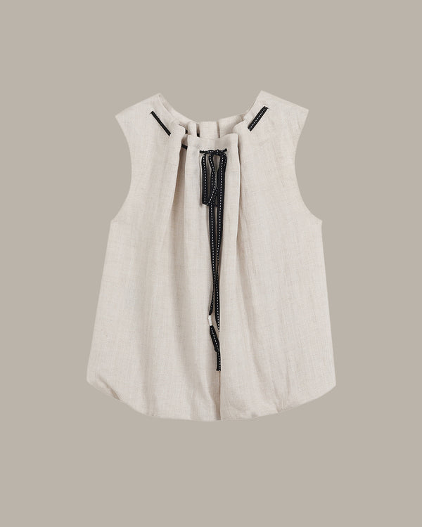 White sleeveless top with black zipper on a beige background