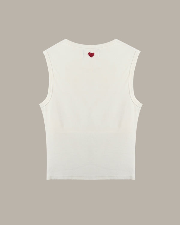 White sleeveless top with a red heart on a beige background