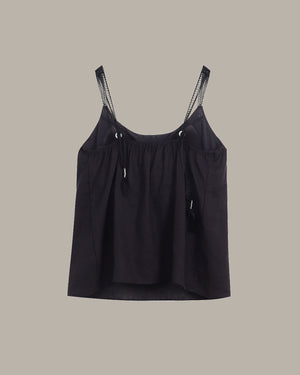 Black tank top with lace trim straps on a beige background