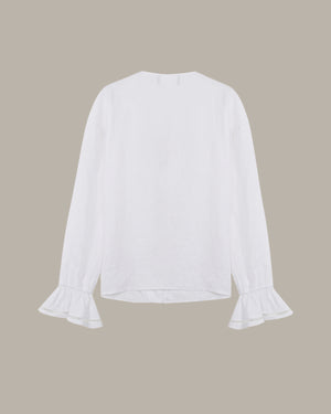 White blouse with ruffled sleeves on a beige background