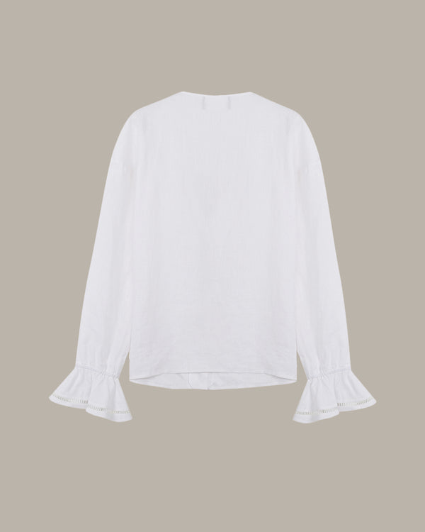 White blouse with ruffled sleeves on a beige background