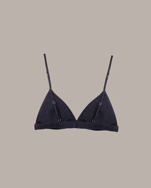 Black bralette with thin straps on a beige background