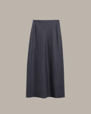A dark charcoal gray knit midi skirt with a subtle textured pattern, shown flat against a solid taupe-gray background.