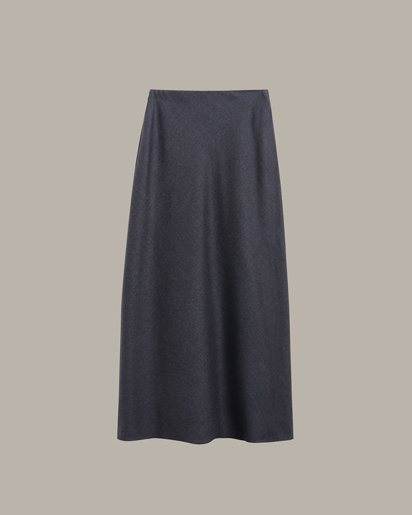A dark charcoal gray knit midi skirt with a subtle textured pattern, shown flat against a solid taupe-gray background.