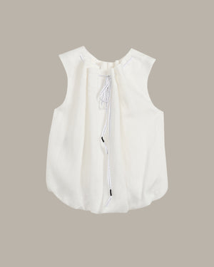 White sleeveless blouse with a zipper on a beige background