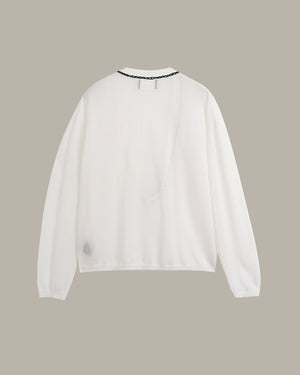 A white long-sleeve top with a crew neck and a delicate black beaded trim, shown from the back against a solid taupe background.