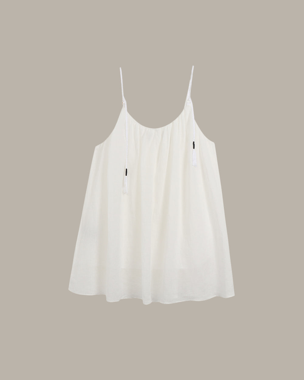 White cami with a black heart on a beige background