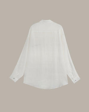 A white long-sleeve blouse with a high mock neck and subtle front pleats, displayed flat against a solid taupe background.