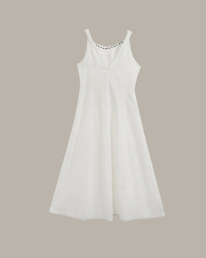 A white sleeveless V-neck dress with a flared skirt, shown against a solid taupe background.
