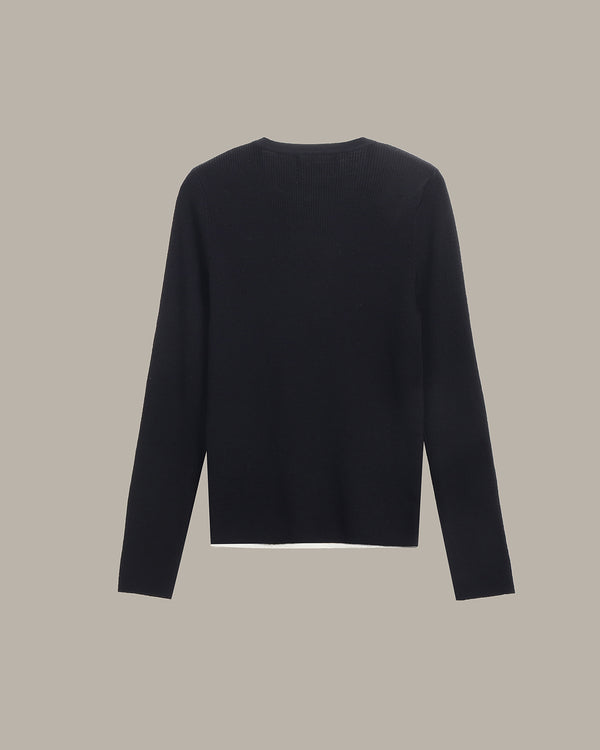 A black long-sleeve knit sweater shown from the back, centered against a solid warm gray background.