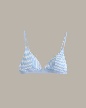 A light blue and white striped triangle bralette with thin adjustable shoulder straps, shown against a solid taupe background.