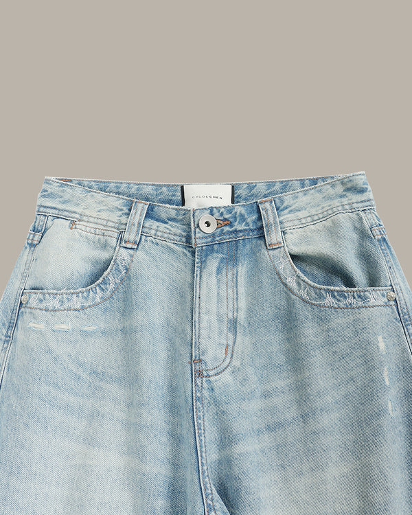 Light blue denim jeans on a gray background