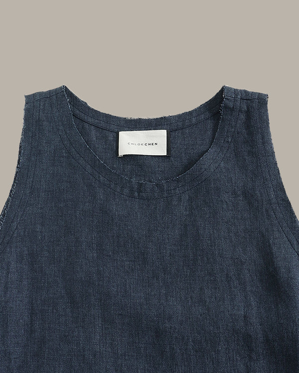 Dark denim sleeveless top with a brand label on a gray background