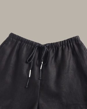 Black pants with drawstring on a beige background