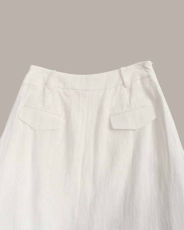 Close-up of a white skirt with a plain background