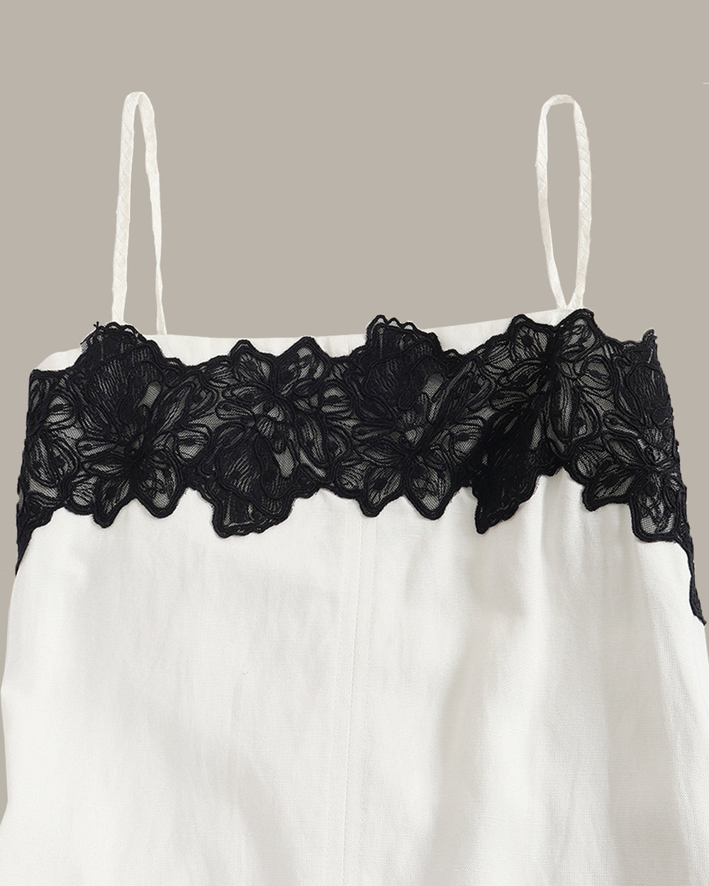 White dress with black lace on a beige background