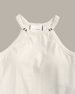White ribbed tank top with brand logo on a gray background