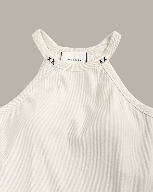 White ribbed tank top with brand logo on a gray background