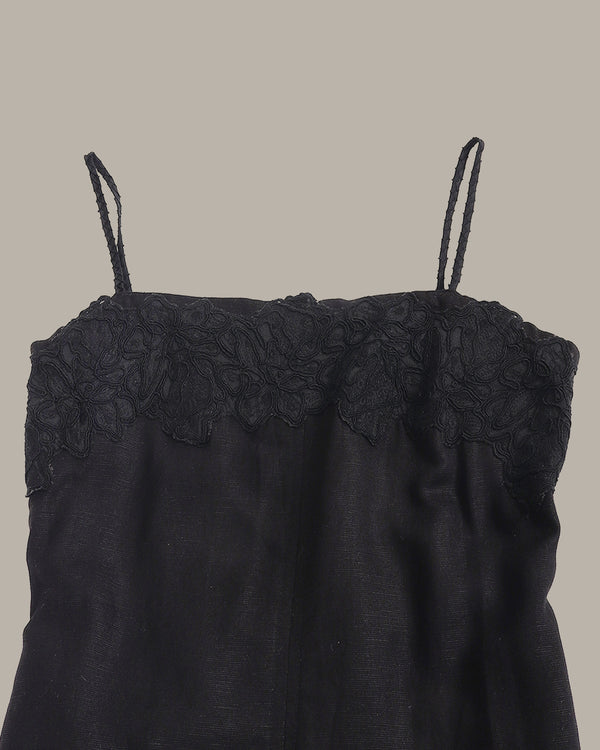 Black lace-trimmed top on a beige background