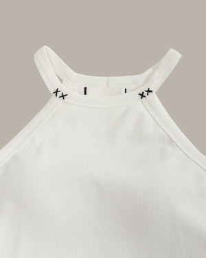 White ribbed tank top with black stitch on the crew neck on a beige background