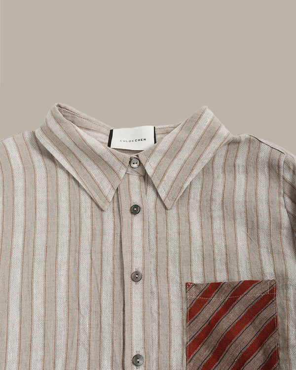 Striped shirt with a pocket featuring a red and brown pattern on a beige background