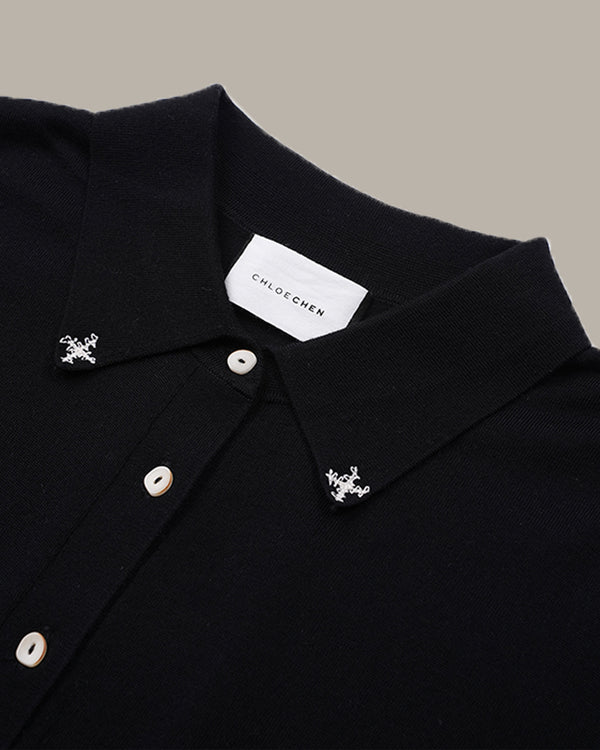 Close-up of a black knit polo shirt collar with silver-toned decorative studs and a white neck label reading CHLOE CHEN.