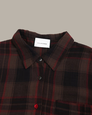 Brown and red plaid shirt with a visible brand label on a neutral background