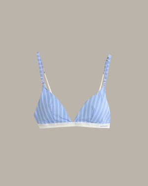 A light blue and white striped triangle bralette with thin adjustable straps and a white underband, shown against a solid taupe background.