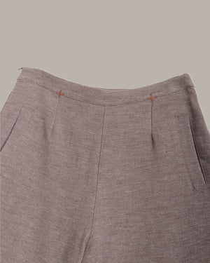 Close-up of brown pants with a plain background