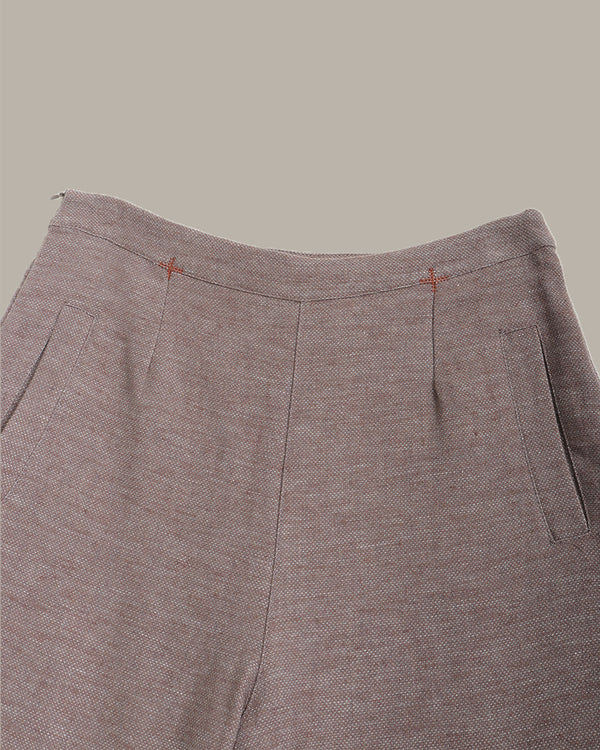 Close-up of brown pants with a plain background