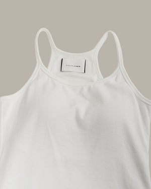 White tank top with a brand label on a beige background