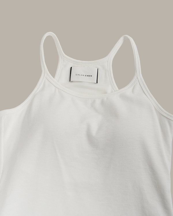 White tank top with a brand label on a beige background