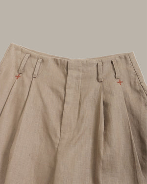 Beige pants with small red logos on a neutral background