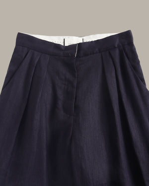 Navy blue pleated skirt on a neutral background