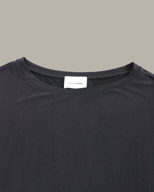 Black t-shirt with a brand label on a gray background