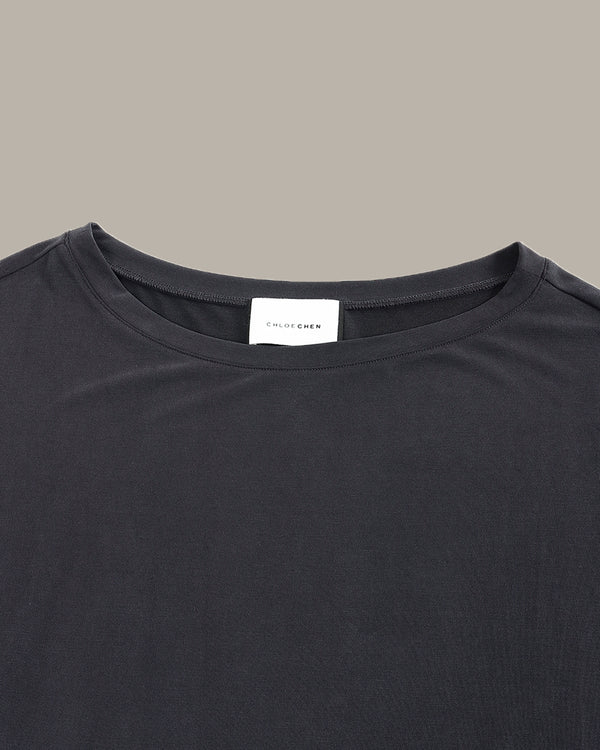 Black t-shirt with a brand label on a gray background