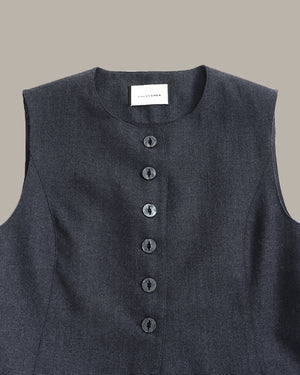 A close-up of a dark charcoal gray sleeveless top with a button-down front and a visible 'LOUISER' brand label at the neckline, set against a solid taupe background.