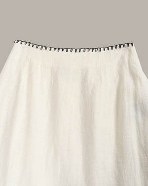 White curtain with black trim on a gray background