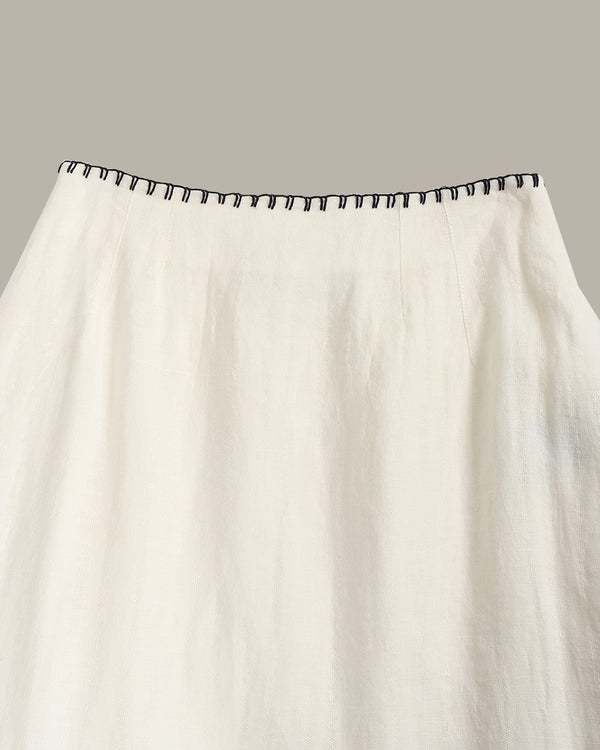 White curtain with black trim on a gray background