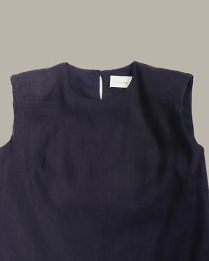Navy sleeveless top with a brand label on a beige background